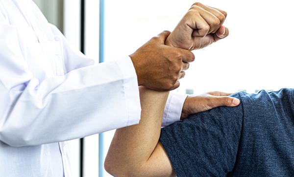 Provider testing a patient's stregth by flexing arm